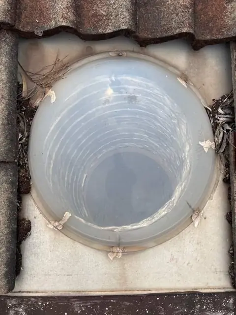 Weathered dome skylight with cracking and sealant repairs