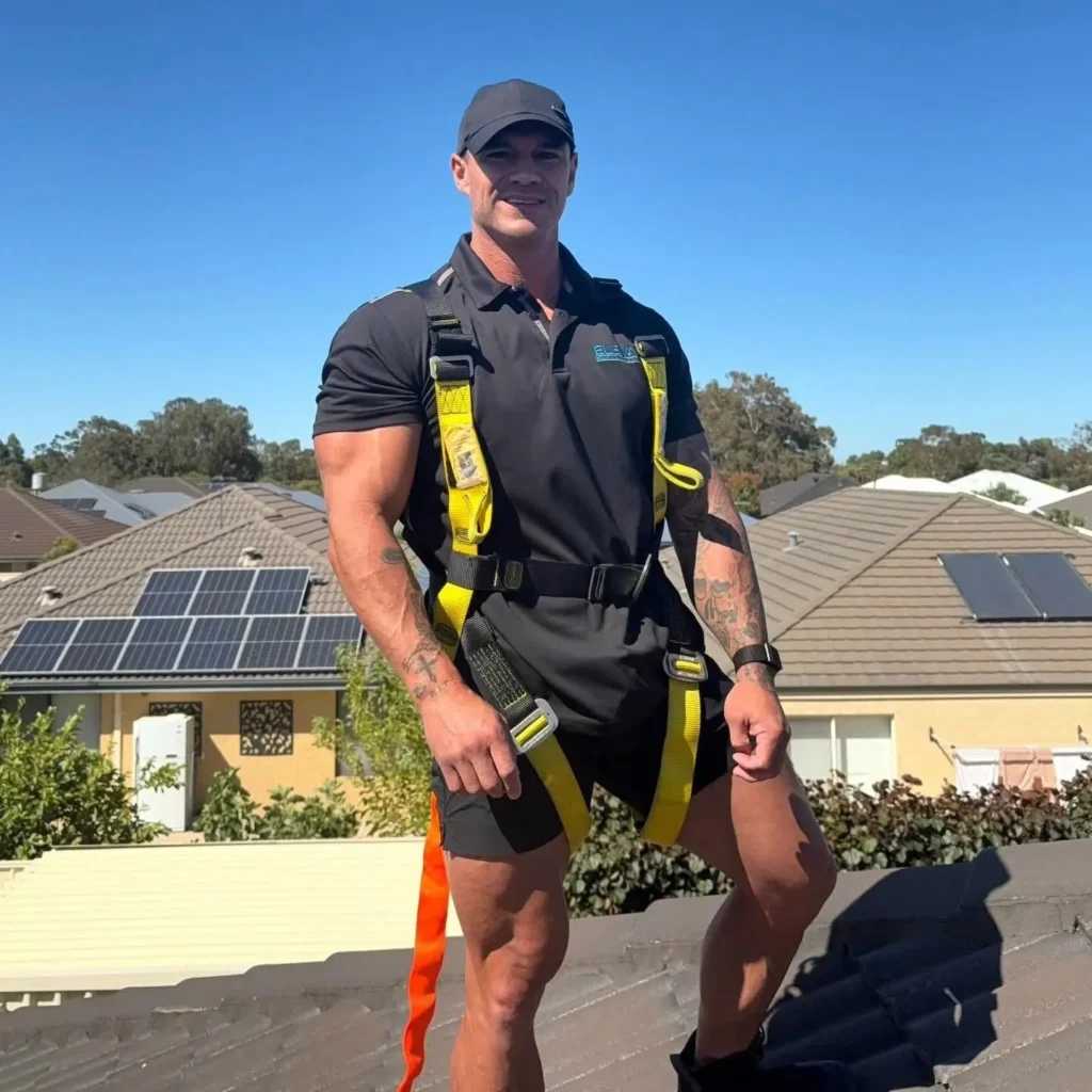 Julian Hunt in a safety harness on a tiled roof
