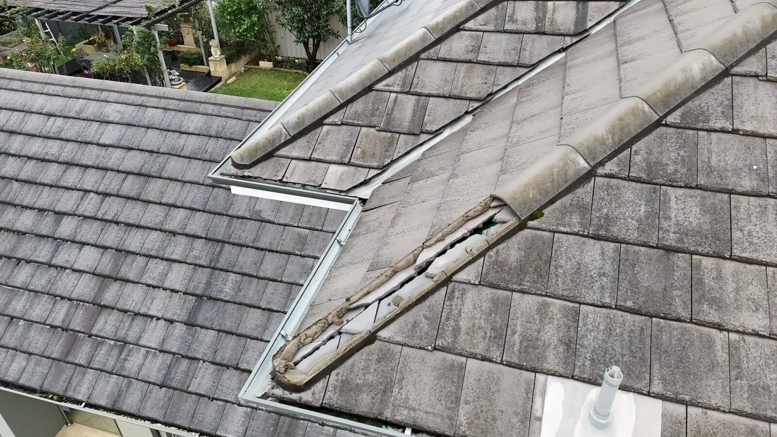 Corroded valley flashing on a concrete tiled roof, drone view