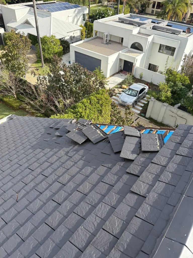 Displaced tiles and exposed sarking on a tiled roof, drone view